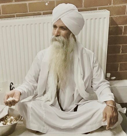Sant Baba Jagjit Singh Ji, seated cross-legged in white